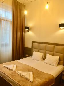 a bedroom with a large bed with two napkins on it at Iveria in Batumi +86 photos