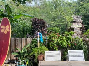 a garden with two chairs and a sign with a surfboard at La kaze manguiers in Étang-Salé