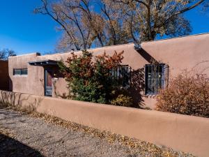 ein rosa Haus mit einem Zaun davor in der Unterkunft La Vida Buena, 2 Bedrooms, Sleeps 4, Fireplace, Patio, Yard, Grill in Santa Fe