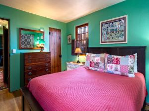 ein Schlafzimmer mit grünen Wänden und einem Bett mit einer roten Tagesdecke in der Unterkunft La Vida Buena, 2 Bedrooms, Sleeps 4, Fireplace, Patio, Yard, Grill in Santa Fe