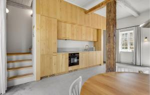 a kitchen with wooden cabinets and a wooden table at Stunning Apartment In Humble With Wifi in Humble