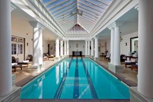 an indoor pool with columns and a ceiling at The Grand Hotel - Heritage Grand in Nuwara Eliya