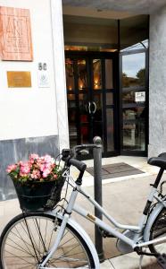 a bike parked in front of a building with a basket of flowers at Art Hotel Pietrasanta in Pietrasanta