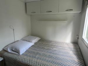 ein kleines Schlafzimmer mit einem Bett in der Ecke in der Unterkunft Le jardin de Jade in Bédarrides