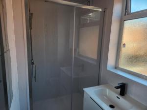 a bathroom with a glass shower and a sink at Long Stay, Contractors, Stags & Hens in Elswick