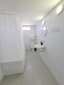 een witte badkamer met een toilet en een wastafel bij Fellini talpiot roof dolce vita in Haifa