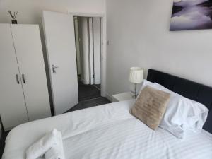 1 dormitorio con 1 cama con sábanas y almohadas blancas en Long Stay, Contractors, Stags & Hens, en Elswick