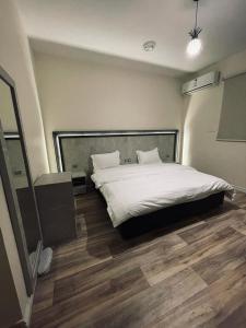 1 dormitorio con 1 cama y suelo de madera en sky hotel en Al Ula