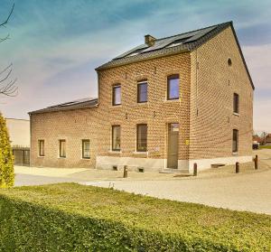 a large brick building with a roof at lit-loo in Kortessem