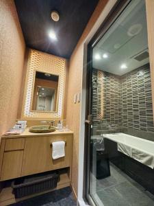a bathroom with a shower and a sink and a tub at ひがし茶屋街らしく金沢 Hotel Rashiku kanazawa in Kanazawa