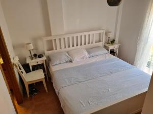 1 dormitorio con 1 cama blanca y 2 almohadas en Pinares de Lepe, en Huelva