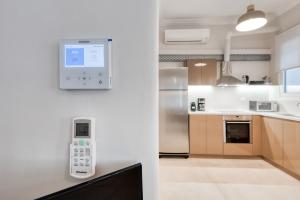 uma cozinha com um dispositivo electrónico na parede em Modern 2-bedroom apt, 200m from the Acropolis em Atenas mais 18 fotografias