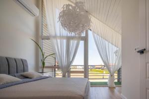 a bedroom with a bed and a large window at Forest Cottage in Palanga