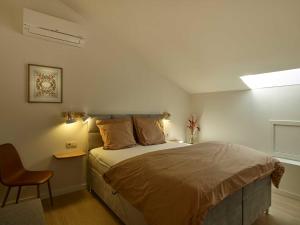 um quarto com uma cama grande e uma cadeira em lit-loo em Hasselt