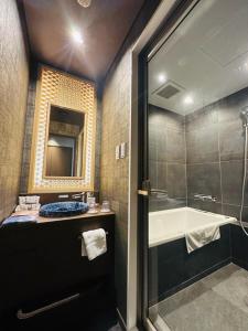 a bathroom with a shower and a sink and a tub at ひがし茶屋街らしく金沢 Hotel Rashiku kanazawa in Kanazawa