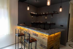 a kitchen with a stone counter with two bar stools at Imlil apartment in Azrou