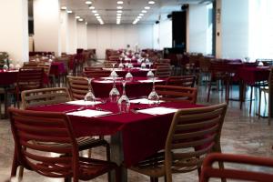 a dining room with red tables and chairs with wine glasses at Ágora Spa & Resort in Peniscola