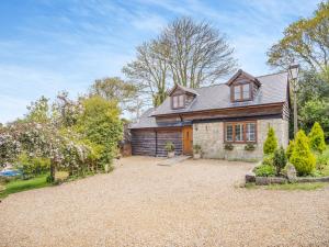 an old stone house with a gravel driveway at Red Squirrel Cottage in Niton