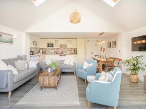 uma sala de estar com cadeiras azuis e uma mesa em Red Squirrel Cottage em Niton