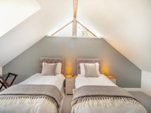 two beds in a attic room with a window at Red Squirrel Cottage in Niton