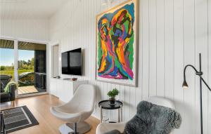 a living room with a painting on the wall at Amazing Home In rsted With House Sea View in Kare