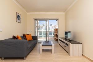 a living room with a couch and a tv at Numar S by ALGARVEMANTA in Manta Rota