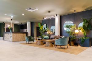 un vestíbulo con plantas, mesa y sillas en Amazonia Apartments, en Timisoara