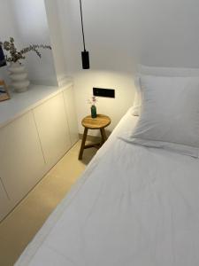a bedroom with a white bed and a small table at NR Urban Torre 2 in Santa Cruz de Tenerife