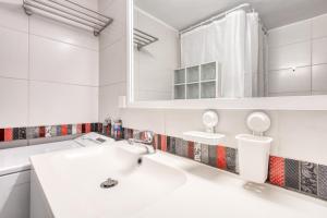 um banheiro branco com uma pia e um espelho em Modern 2-bedroom apt, 200m from the Acropolis em Atenas