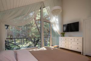 a bedroom with a bed and a large window at Forest Cottage in Palanga