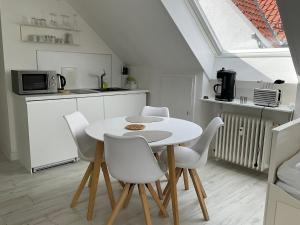 cocina blanca con mesa y sillas blancas en City Apartment gegenüber vom Kurhaus, en Freudenstadt