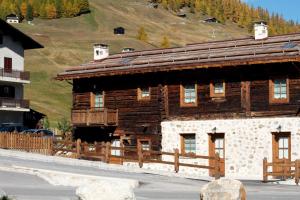 a wooden building with a fence in front of it at Casa Gallo in Livigno