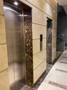 a elevator in a building with marble walls at Jood Residences Apartment in Cairo