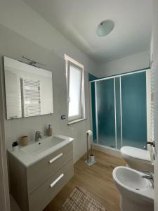 een witte badkamer met een wastafel en een toilet bij Home Fiori d’Angelo in Agropoli