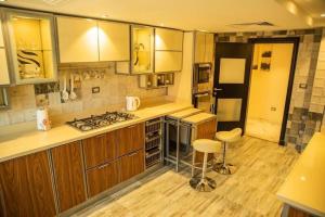 a kitchen with wooden cabinets and a stove top oven at Jood Residences Apartment in Cairo