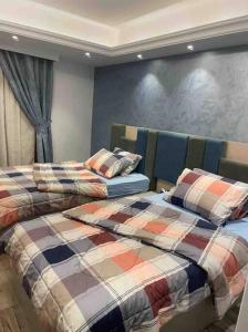 twee bedden naast elkaar in een slaapkamer bij Jood Residences Apartment in Caïro