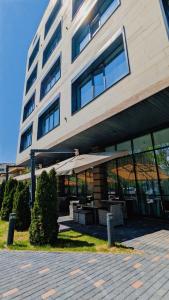 a building with a table and an umbrella in front of it at Raavah Aparthotel in Almaty
