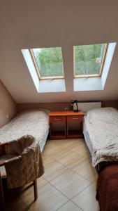 2 camas en una habitación con 2 ventanas en Ośrodek SUDETY, en Jarnołtówek