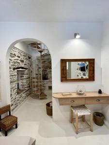 Habitación con lavabo, espejo y mesa. en Captain's Port Studio, en Gavrion