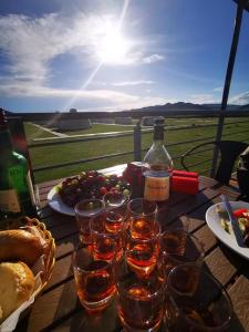 una mesa con copas de vino y una botella de vino en Talbiun Lodge en Hujirt