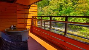 un balcón de una cabaña con vistas a un tren en Shiobara Onsen Ryokan Kamiaizuya en Nasushiobara