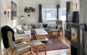 a living room with a couch and a tv at Awesome Apartment In Rros With 3 Bedrooms in Røros