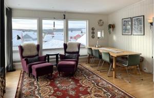 a dining room with a table and chairs and a large window at Gorgeous Apartment In Rros With Kitchen in Røros
