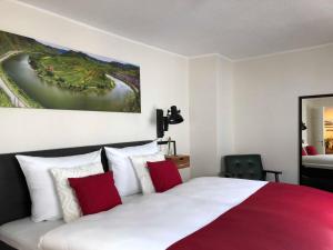 1 dormitorio con 1 cama con almohadas rojas y blancas en Ferienhaus-Am-Alten-Stadttor en Ediger-Eller