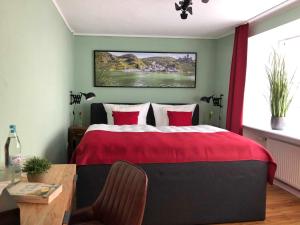 una camera da letto con un letto con un piumone rosso di Ferienhaus-Am-Alten-Stadttor a Ediger-Eller