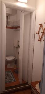 łazienka z toaletą i otwieranymi drzwiami w obiekcie miramare b&b di cerri maria w mieście Le Castella