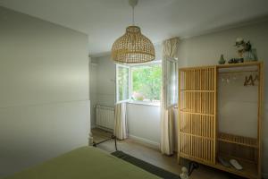 a bedroom with a window and a chandelier at La Rosière in Peso da Régua