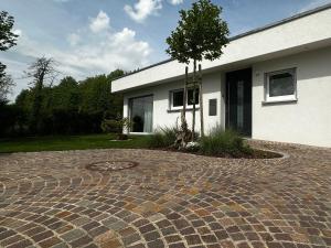 una casa con un vialetto di mattoni di fronte a un edificio di Moderne Ferienwohnung Rhenum mit Wallbox a Waldshut-Tiengen