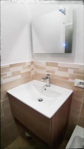 uma casa de banho com um lavatório branco e um espelho. em VistaMare em Villaputzu