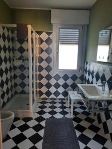 a bathroom with a checkered floor and a sink at Siore Marie gli alloggi in San Giórgio di Nogaro